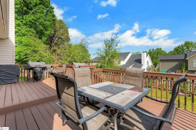 wooden terrace featuring outdoor dining area, a residential view, and area for grilling