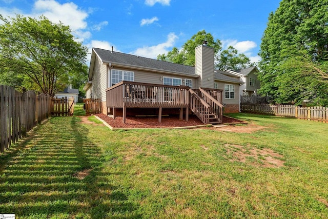 rear view of property featuring a yard, a chimney, a fenced backyard, and a deck