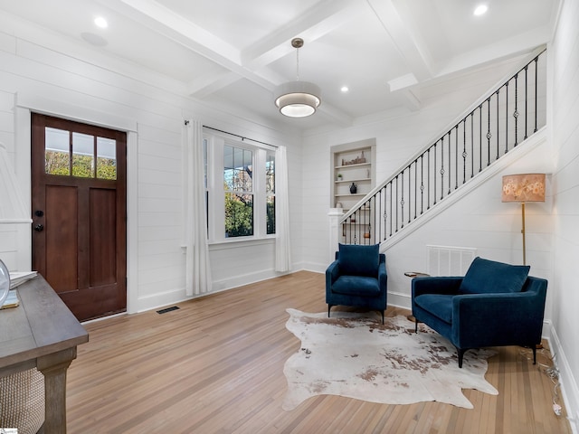 entrance foyer featuring plenty of natural light, wood finished floors, beam ceiling, and stairs