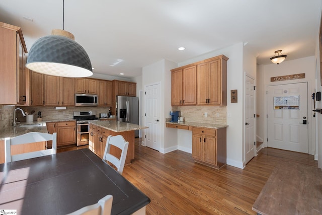 102 Rabon Chase Ct, Fountain Inn, SC 29644 - kitchen with light stone counters, backsplash, wood finished floors, a sink, and appliances with stainless steel finishes
