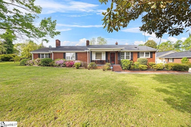 ranch-style home with a front yard, a chimney, and brick siding
