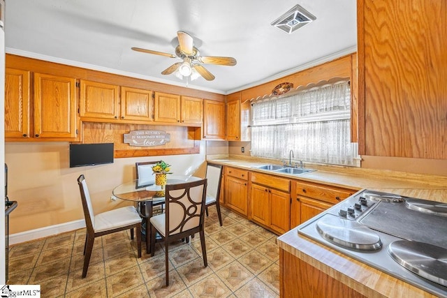 kitchen featuring visible vents, ceiling fan, light countertops, and a sink