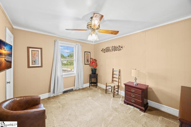 sitting room featuring ornamental molding, a ceiling fan, visible vents, and carpet floors