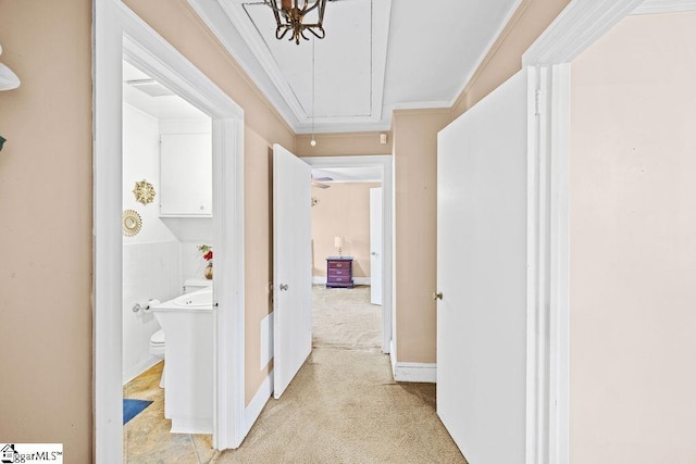 hall featuring attic access, light carpet, and crown molding