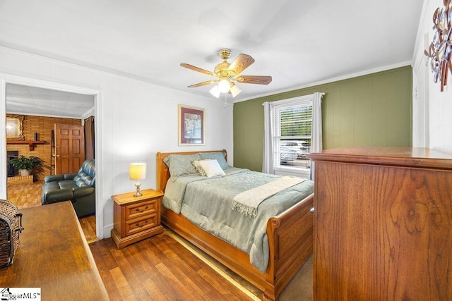 bedroom with dark wood-type flooring, ceiling fan, and crown molding