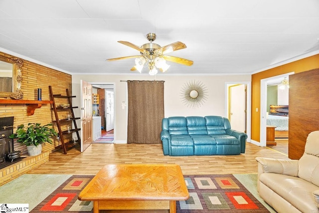living room featuring ornamental molding, a ceiling fan, wood finished floors, and baseboards