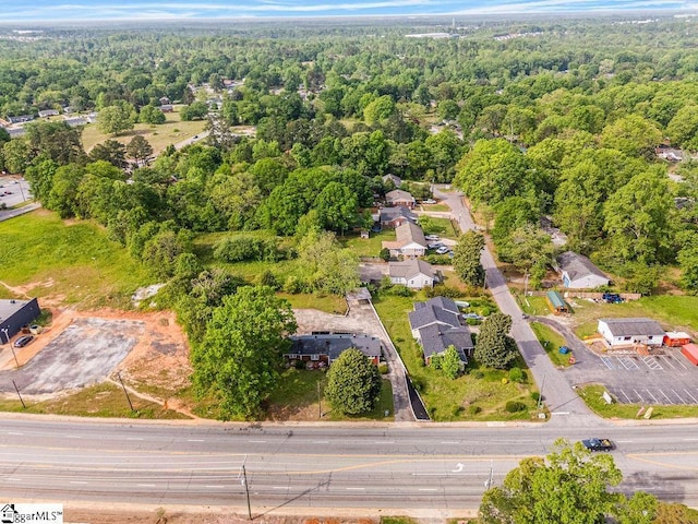 birds eye view of property featuring a wooded view and a residential view