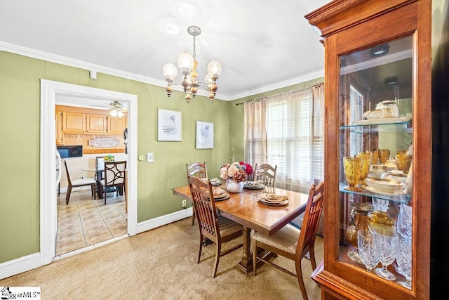 dining space featuring ornamental molding, ceiling fan with notable chandelier, light carpet, and baseboards