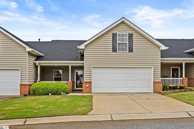 view of front of property featuring a porch, a front yard, and brick siding