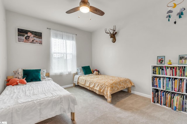 carpeted bedroom with a ceiling fan and baseboards