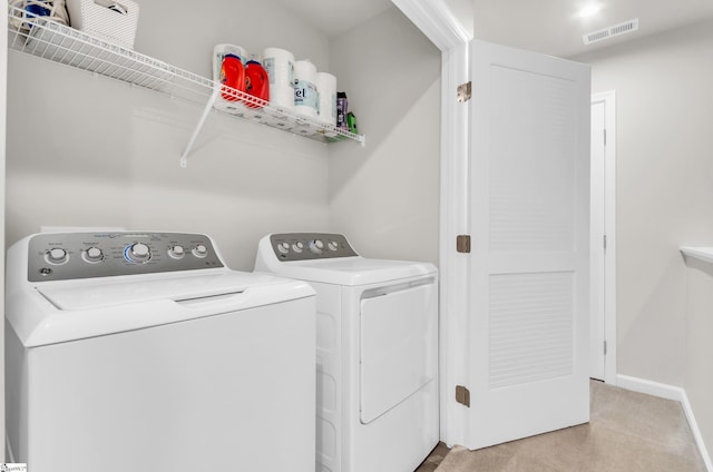 laundry room with visible vents, baseboards, washer and dryer, light carpet, and laundry area