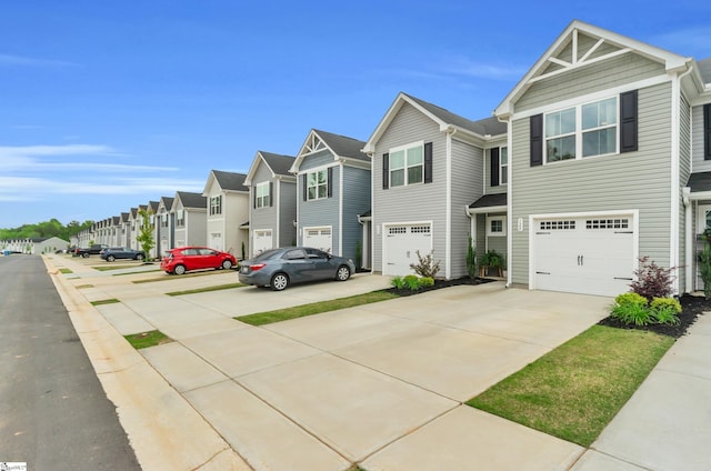 view of front facade with a residential view, driveway, and a garage
