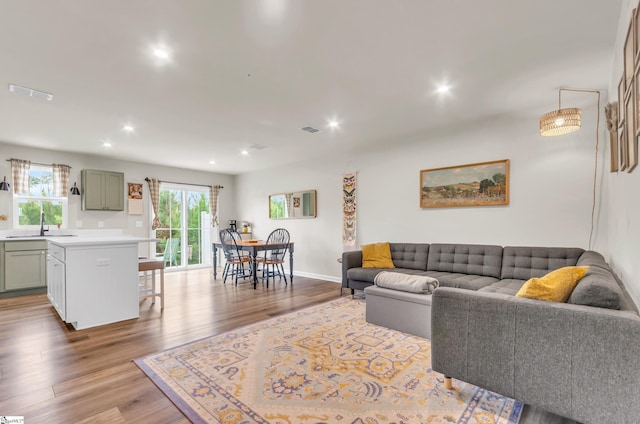 living area with visible vents, recessed lighting, wood finished floors, and baseboards