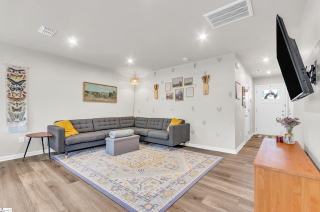 living area with visible vents, baseboards, and light wood-style floors