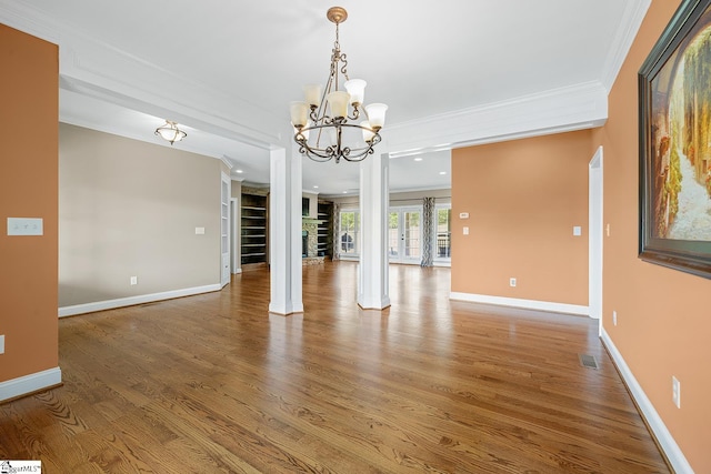 unfurnished dining area featuring visible vents, wood finished floors, and crown molding