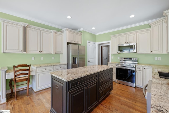 kitchen featuring white cabinets, stainless steel appliances, recessed lighting, ornamental molding, and light wood finished floors