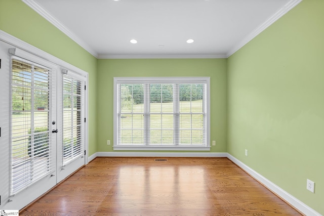 unfurnished room with crown molding, french doors, wood finished floors, and baseboards