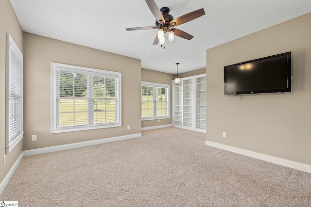 unfurnished living room with baseboards, ceiling fan, and carpet