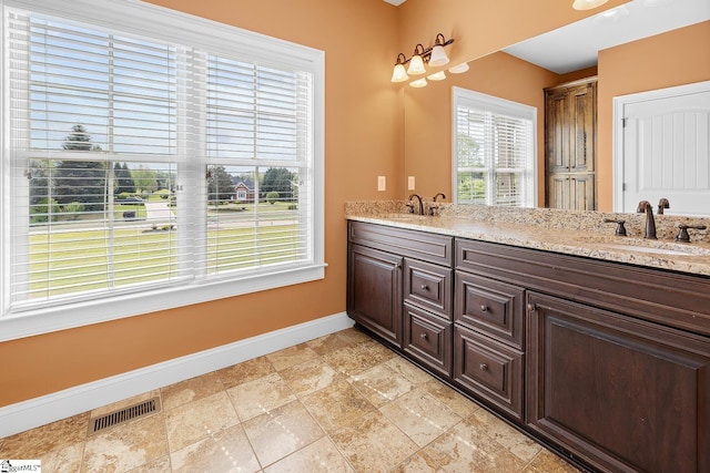 full bath with a sink, plenty of natural light, visible vents, and baseboards