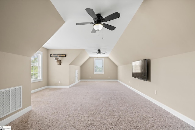 bonus room with lofted ceiling, visible vents, ceiling fan, baseboards, and carpet