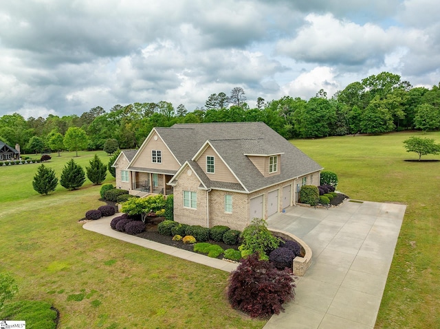 craftsman house with a garage, brick siding, a front lawn, and driveway