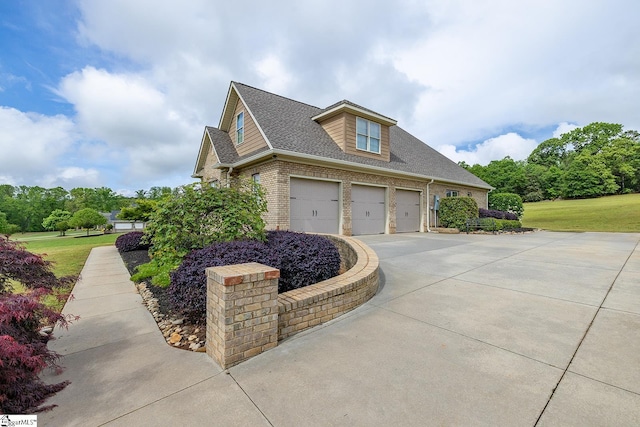 view of home's exterior with driveway, a yard, a shingled roof, and brick siding