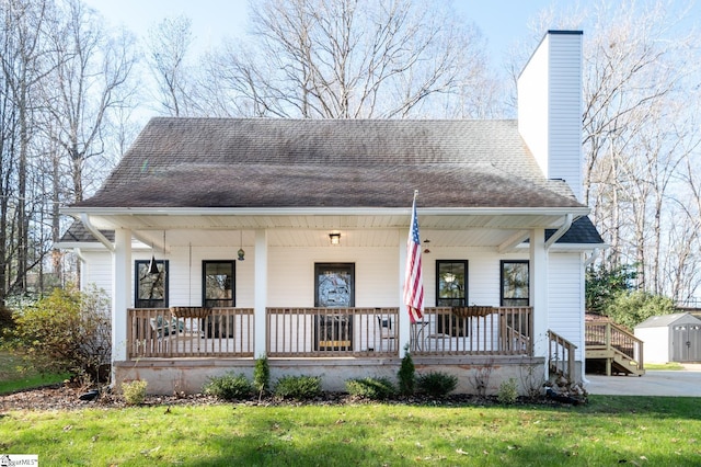 203 W Dr, Travelers Rest, SC 29690 - view of front facade featuring a front yard, a shingled roof, covered porch, and a chimney