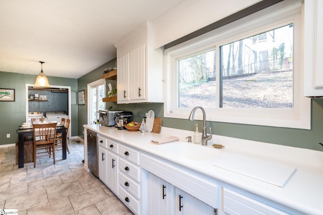 203 W Dr, Travelers Rest, SC 29690 - kitchen featuring washer and dryer, light countertops, a sink, white cabinetry, and pendant lighting