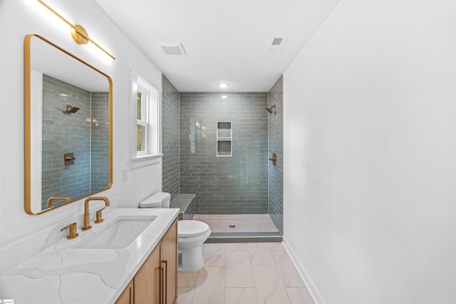 bathroom with a tile shower, toilet, visible vents, and marble finish floor