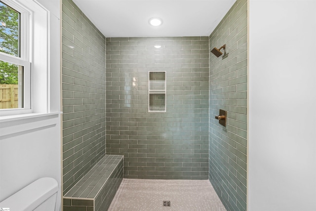 bathroom with a tile shower, toilet, and recessed lighting