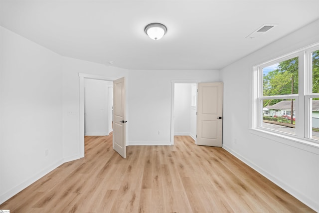 unfurnished bedroom featuring visible vents, light wood-style flooring, and baseboards