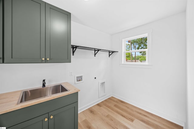 laundry area with light wood-style flooring, electric dryer hookup, cabinet space, washer hookup, and a sink