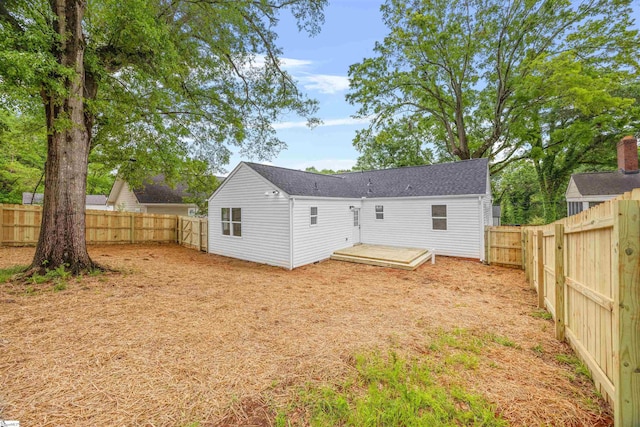 rear view of house featuring a fenced backyard and a wooden deck