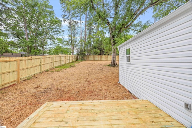 view of yard with a wooden deck and a fenced backyard