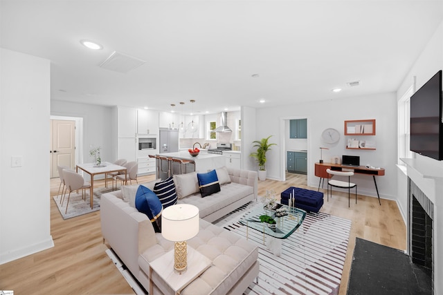 living room featuring visible vents, recessed lighting, light wood-style flooring, and baseboards