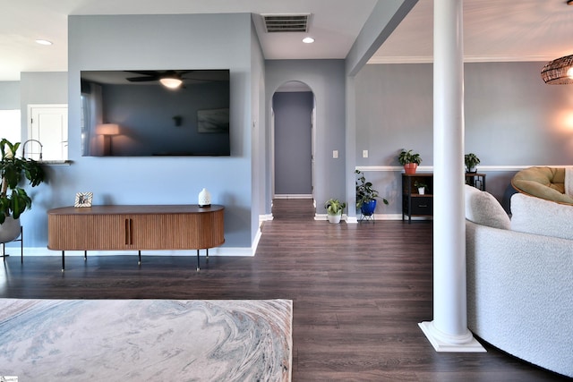 bedroom featuring visible vents, baseboards, ornate columns, arched walkways, and wood finished floors