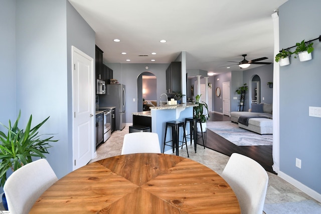 dining space featuring recessed lighting, a ceiling fan, visible vents, baseboards, and arched walkways