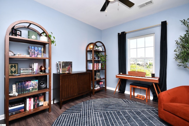 living area with baseboards, visible vents, wood finished floors, and ceiling fan