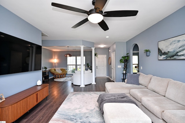 living area with a ceiling fan, dark wood-style floors, and arched walkways