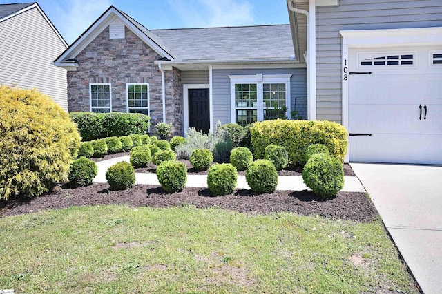 view of front of property with a garage, a front lawn, and stone siding