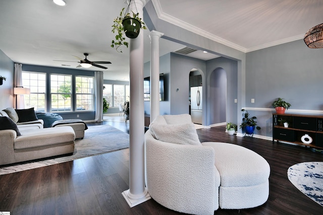 living area with decorative columns, a ceiling fan, baseboards, arched walkways, and wood finished floors