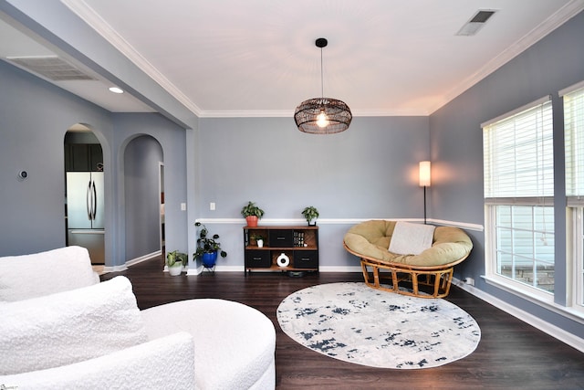 living area featuring arched walkways, visible vents, wood finished floors, and baseboards