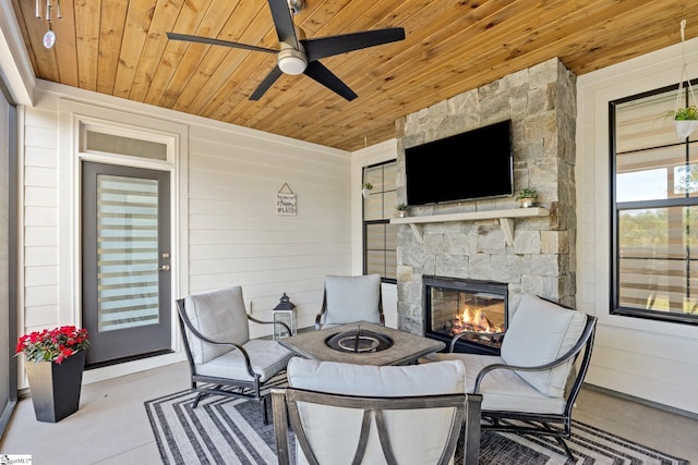 view of patio / terrace featuring ceiling fan and an outdoor stone fireplace