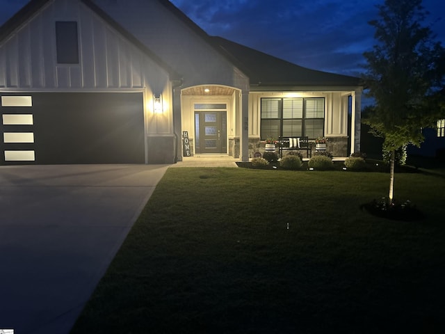 single story home featuring concrete driveway, a lawn, an attached garage, and covered porch