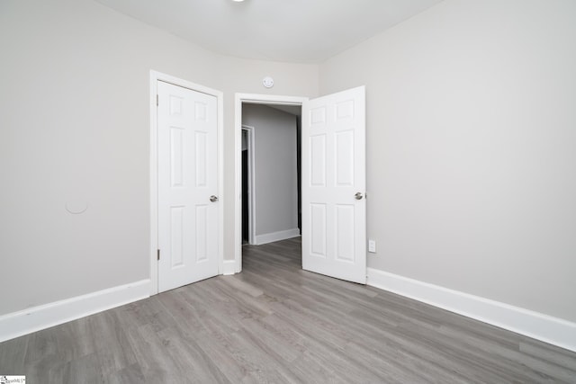 unfurnished room with wood finished floors and baseboards