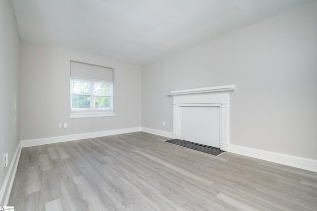 unfurnished living room featuring wood finished floors and baseboards