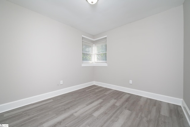 unfurnished room featuring wood finished floors and baseboards