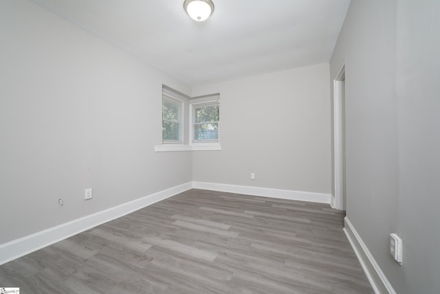 empty room featuring wood finished floors and baseboards