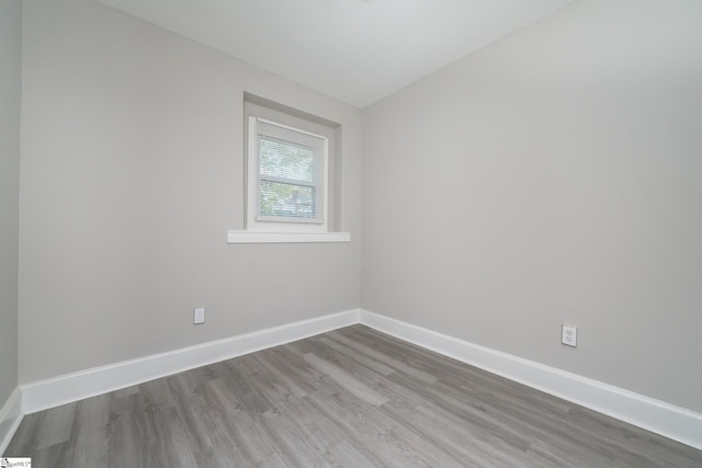 unfurnished room with baseboards and wood finished floors