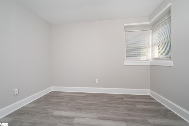 empty room with wood finished floors and baseboards
